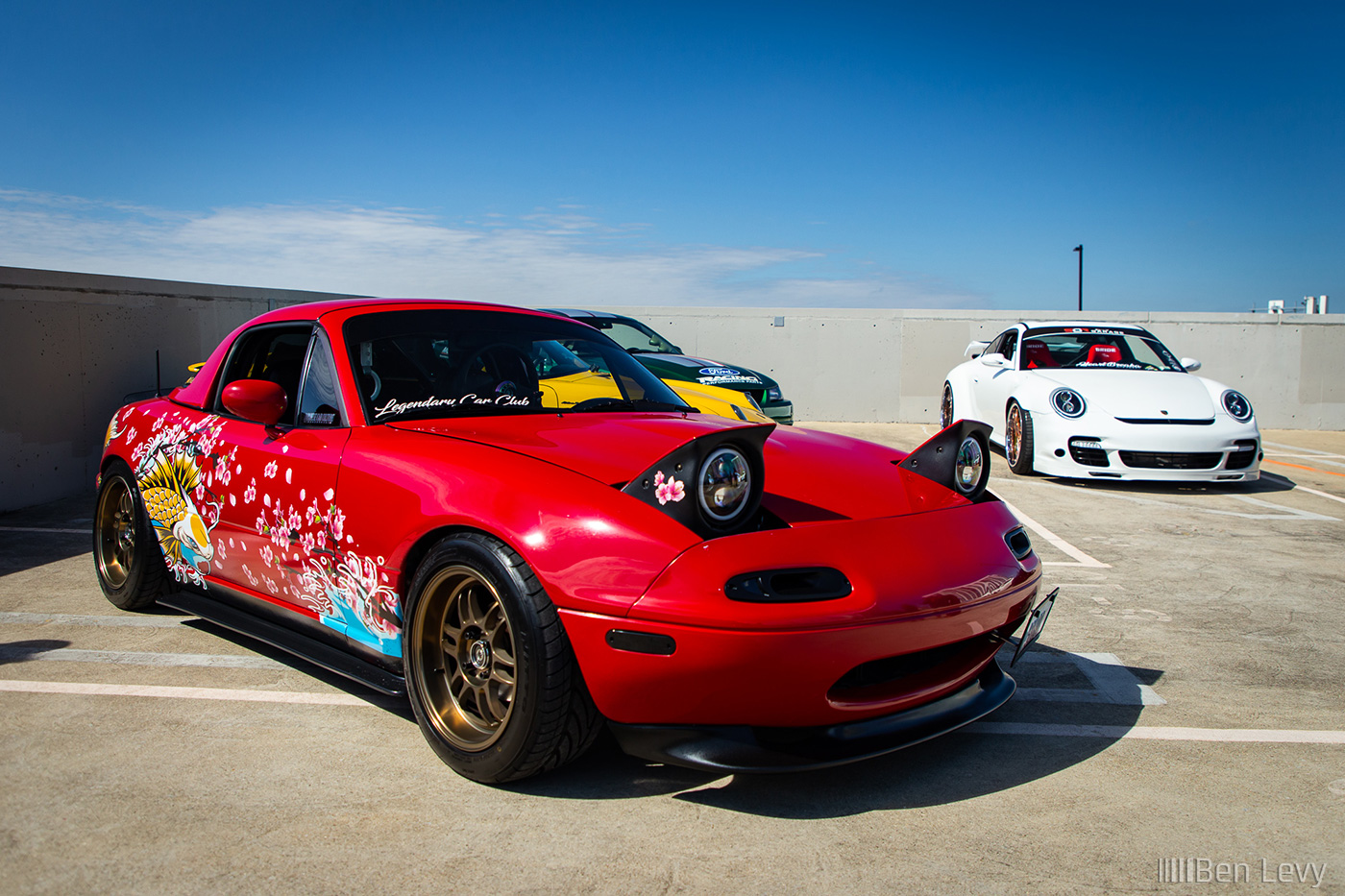 Red 1990 Miata with Japanese Graphics on the Side