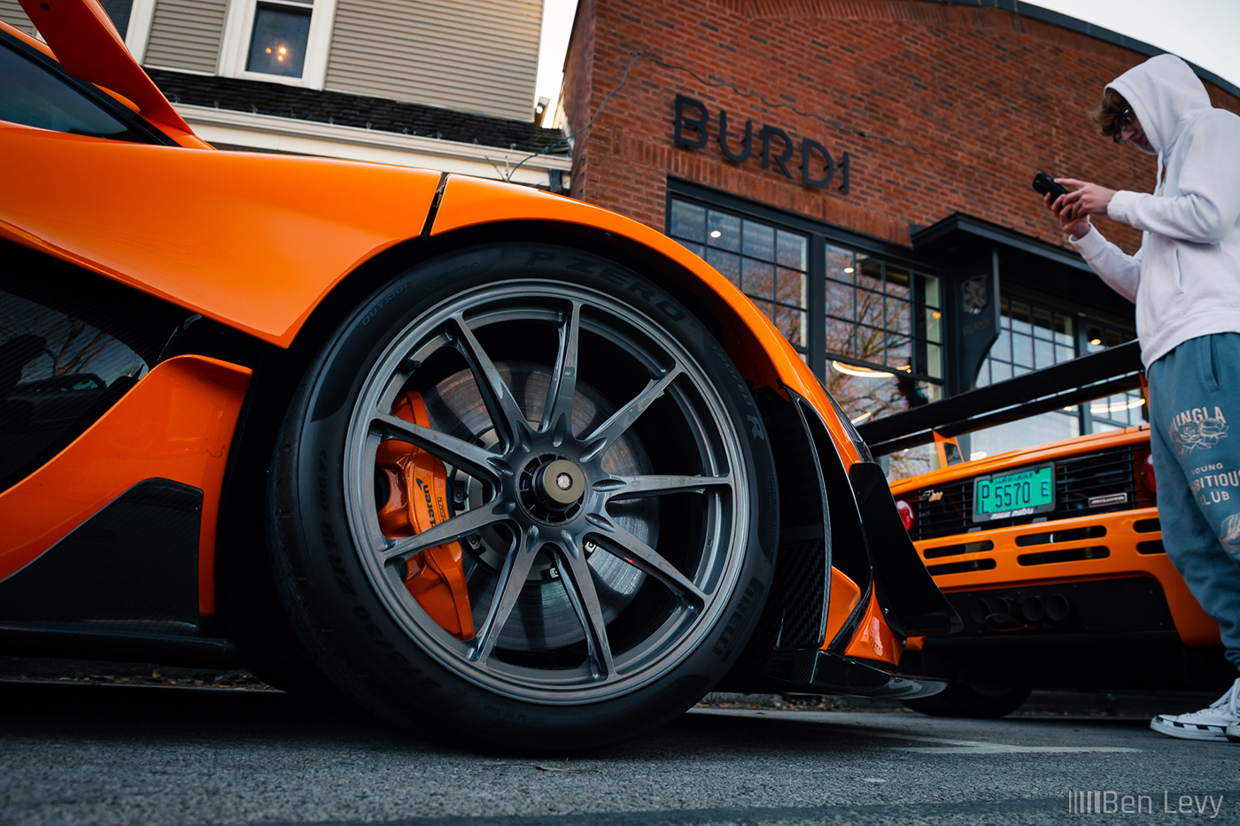 Wheel of Orange McLaren P1 LM in front of Burdi Clothing in Hinsdale