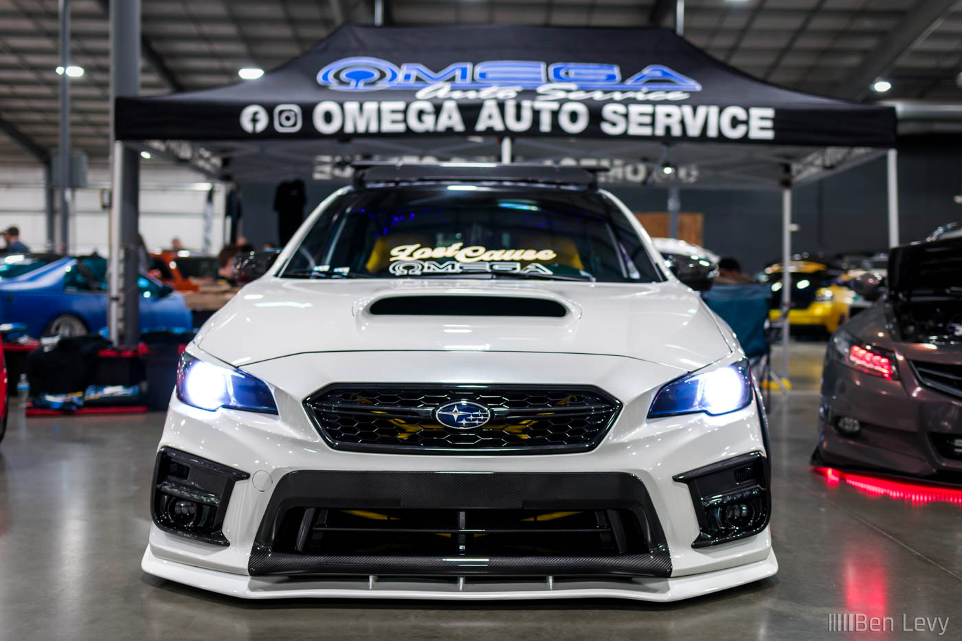 Front of White Subaru WRX at Omega Auto Service Booth