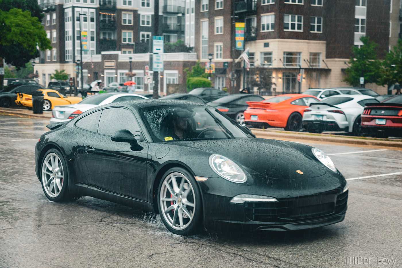 Black 911 Carrera S Driving in a Wet Parking Lot