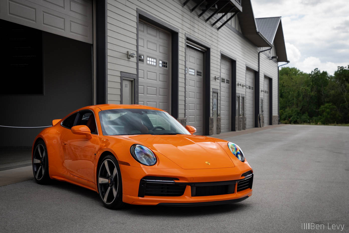 Oraneg Porsche 911 Sport Classic in front of luxory garage condos