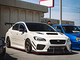 White Subaru WRX STI with Red Accent on Lips and Sideskirts