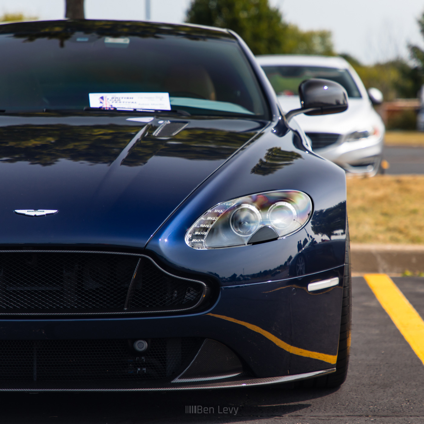 Close-up Shot of the Headlight of a Dark Blue Aston Martin Vantage