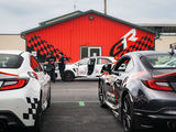 Tail Lights of two Toyotas in front of a Building with a Gazoo Racing Theme