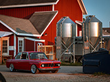 Red BMW 2002 Parked Behind a Farmhouse