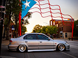 Side of Silver Honda Civic under Puerto Rican Flag on Paseo Boricua