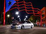 Silver Civic with Honda Domani Conversion under Puerto Rican Flag on Paseo Boricua