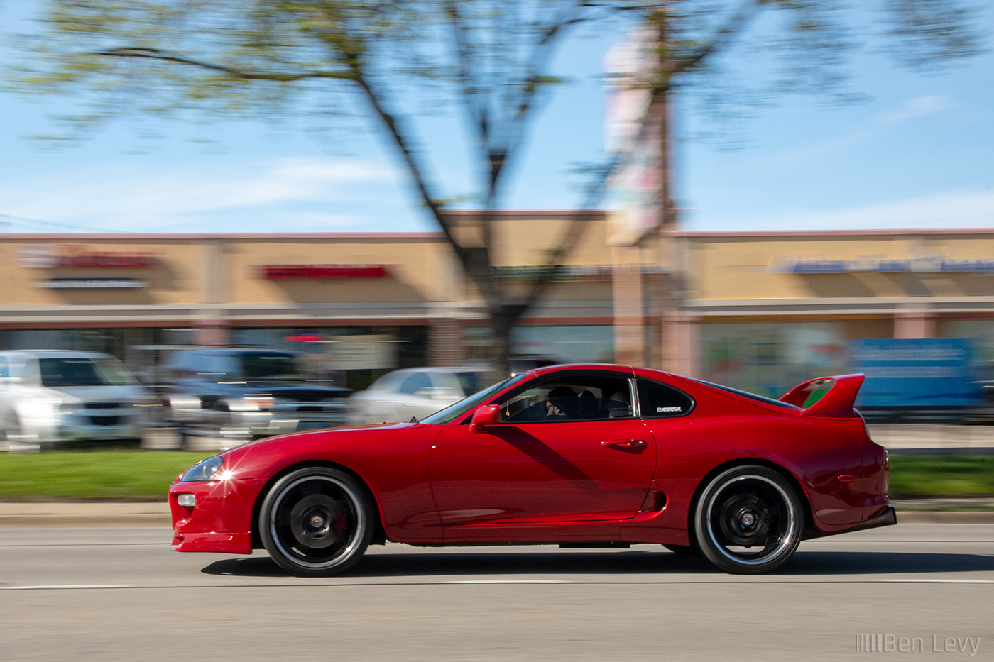 Red Toyota Supra passing on the street