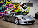Silver Porsche Carrera GT in Front of Wall of Graffiti