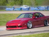 Red Nissan 240SX on the track