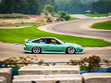 Green Nissan 240SX on the track