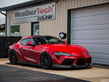 Red A90 Toyota Supra parked outside of the WeatherTech TechCenter at Autobahn Country Club