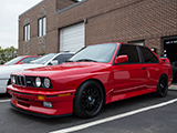 Red E30 BMW M3 on black wheels