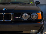 Headlights of a black E34 BMW M5
