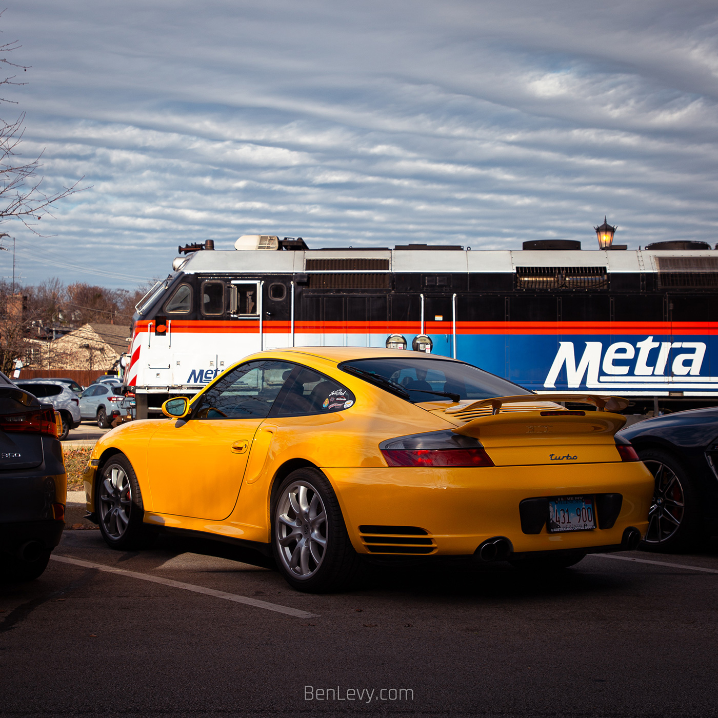 Yellow Porsche 911 Turbo with a Metra Train in the Background