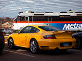 Yellow Porsche 911 Turbo with a Metra Train in the Background