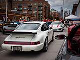 White Porsche 911 RS America parked on the sidewalk for Checkeditout 2021