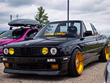 Black E30 BMW on gold wheels