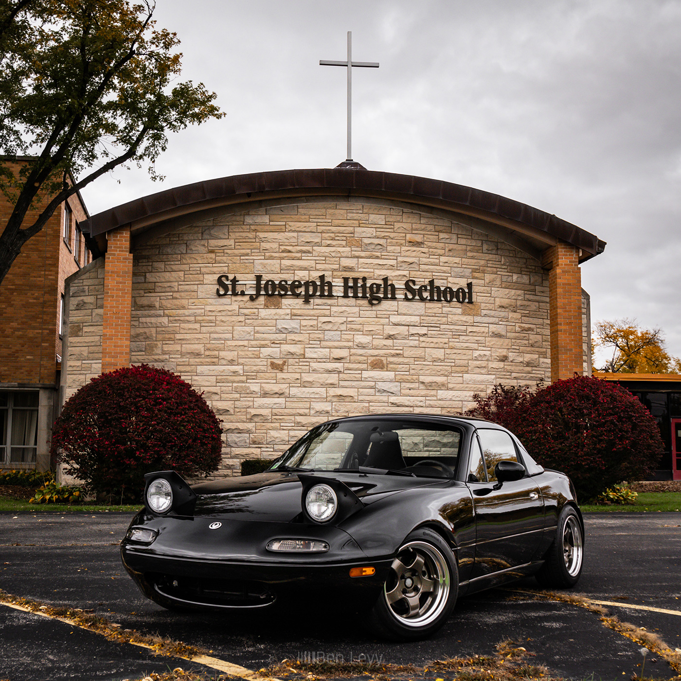 Black Mazda Miata with Hardtop in front of St. Joseph High School