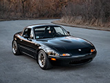 Black Mazda Miata in a Forest Preserve