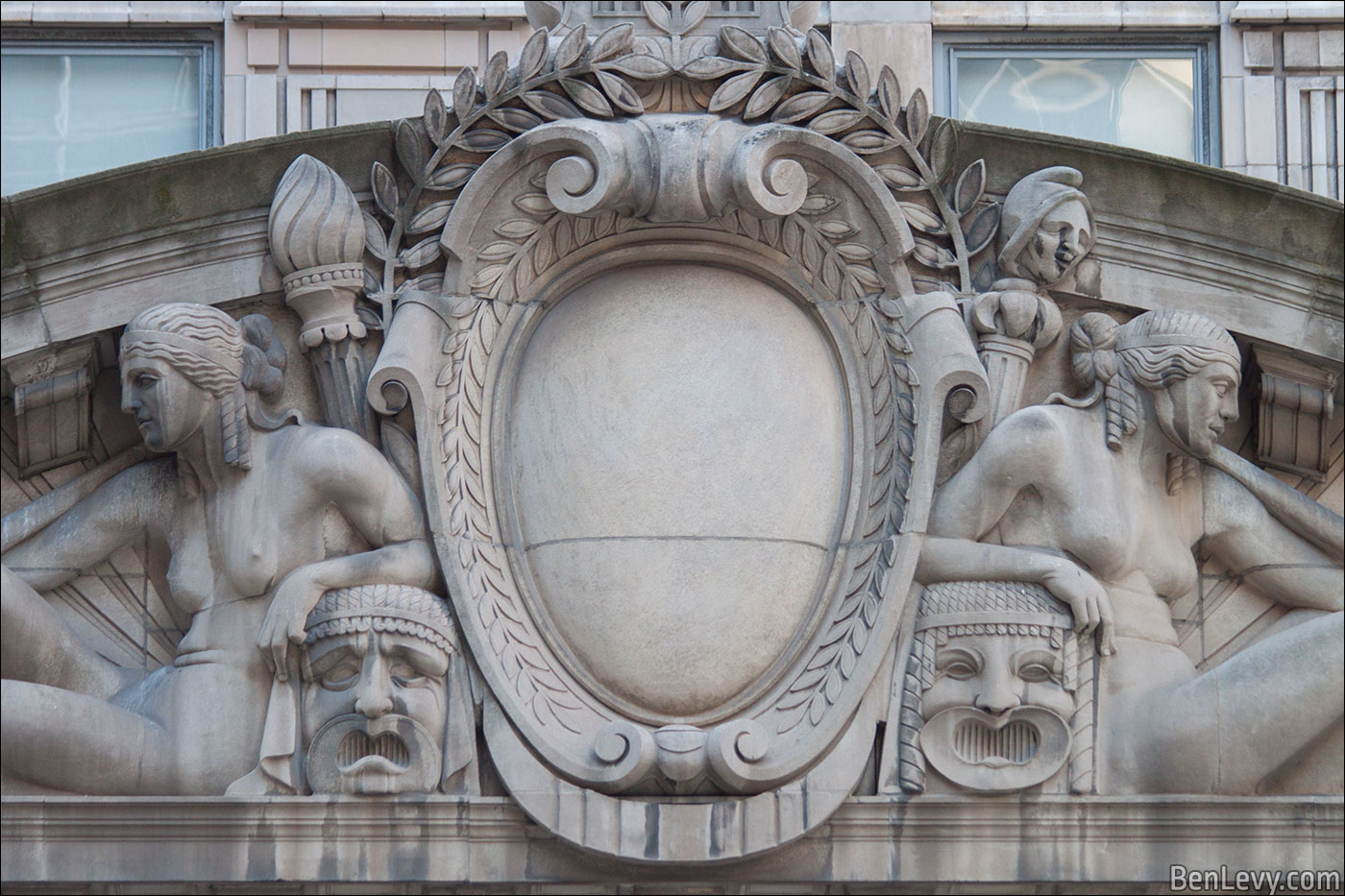 Nude characters with masks on Civic Opera Building